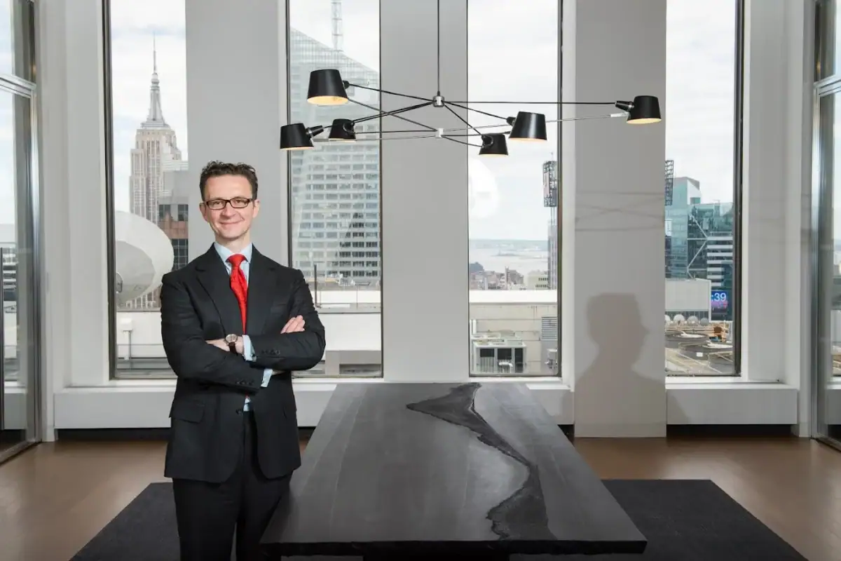 Headshot example featuring a landscape-oriented portrait of a male leader with crossed arms, framed against a high-end office interior and the prominent New York City skyline.
